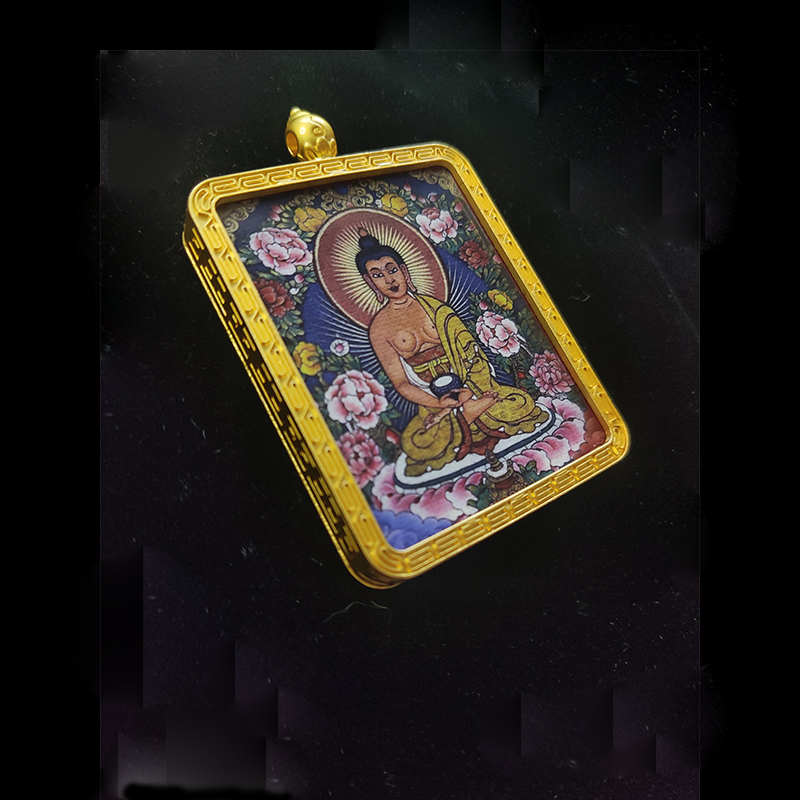 Angled view of the Amitabha Buddha protective amulet, showcasing the gold-tone textured frame and the detailed spiritual artwork of the Buddha of Infinite Life.