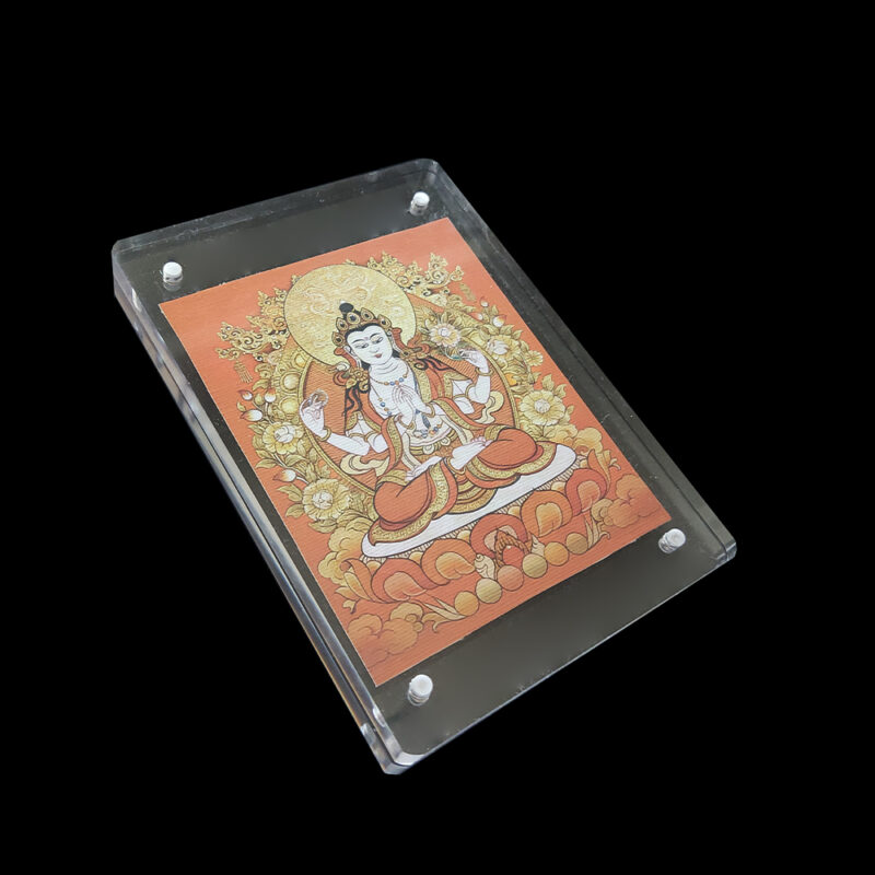 Side angled view of the orange Chenrezig acrylic frame, highlighting the organic texture of the natural canvas and the clear, modern protective case.