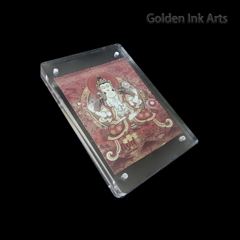 Side angled shot of the red Chenrezig acrylic frame, highlighting the warm, grainy texture of the cotton canvas and the sleek, modern protective casing.