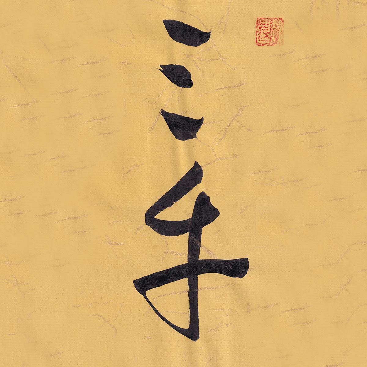 golden-ink-arts-san-cai-cursive-script-calligraphy-wallpaper Two Chinese characters San Cai rendered in expressive cursive script calligraphy on warm ochre textured paper with a red seal stamp at the top right.