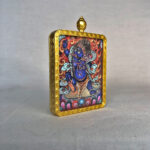 Side-angle view of blue Acala Fudo Myoo brass Gau box necklace pendant.