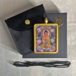 Amitabha Gau box necklace displayed with black cord, pouch, and gift box.