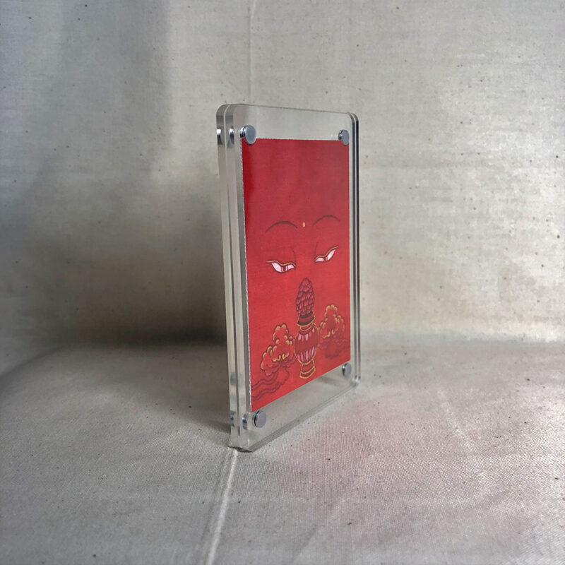 Side-angle view of freestanding clear acrylic block displaying Amitayus line art.