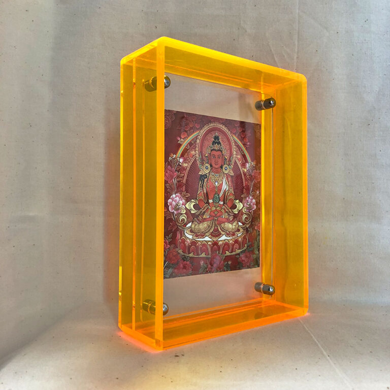 Side perspective of red Amitayus Thangka print inside a yellow translucent acrylic frame.