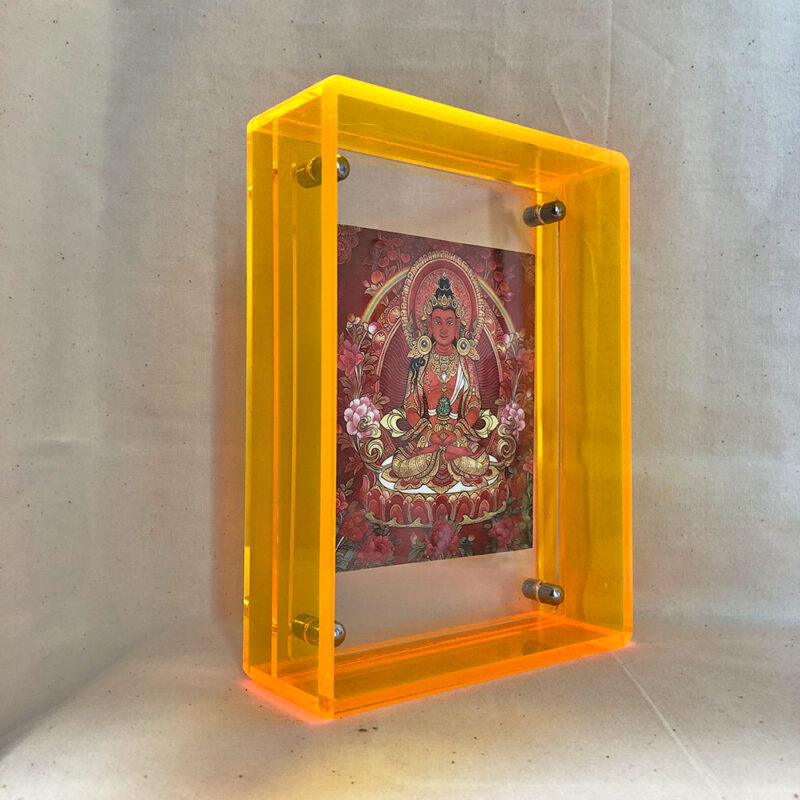 Side perspective of red Amitayus Thangka print inside a yellow translucent acrylic frame.
