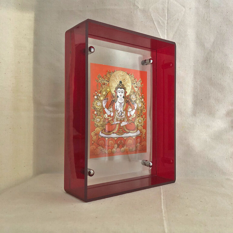 Side perspective of orange Avalokiteshvara Thangka print inside a red acrylic display frame.