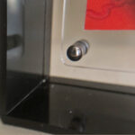 Close-up of magnetic corner screw on smoky black translucent acrylic display block.