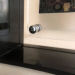 Close-up of magnetic corner screw on translucent black acrylic display block.