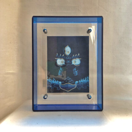 Front view of Black Jambhala Buddha Eyes print in a blue floating translucent acrylic frame.
