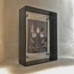 Side perspective of Black Jambhala Buddha Eyes art inside a black translucent acrylic frame.