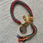 Black Padmasambhava Buddha Eyes Tibetan braided meditation bracelet flatlay on fabric.