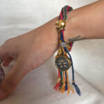 Person wearing the Black Padmasambhava Buddha Eyes braided cord bracelet on wrist.