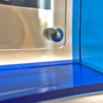 Close-up of magnetic corner screw on sapphire blue translucent acrylic display block.