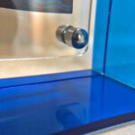 Close-up of magnetic corner screw on sapphire blue translucent acrylic display block.