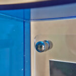 Close-up of magnetic corner screw on royal blue translucent acrylic display block.