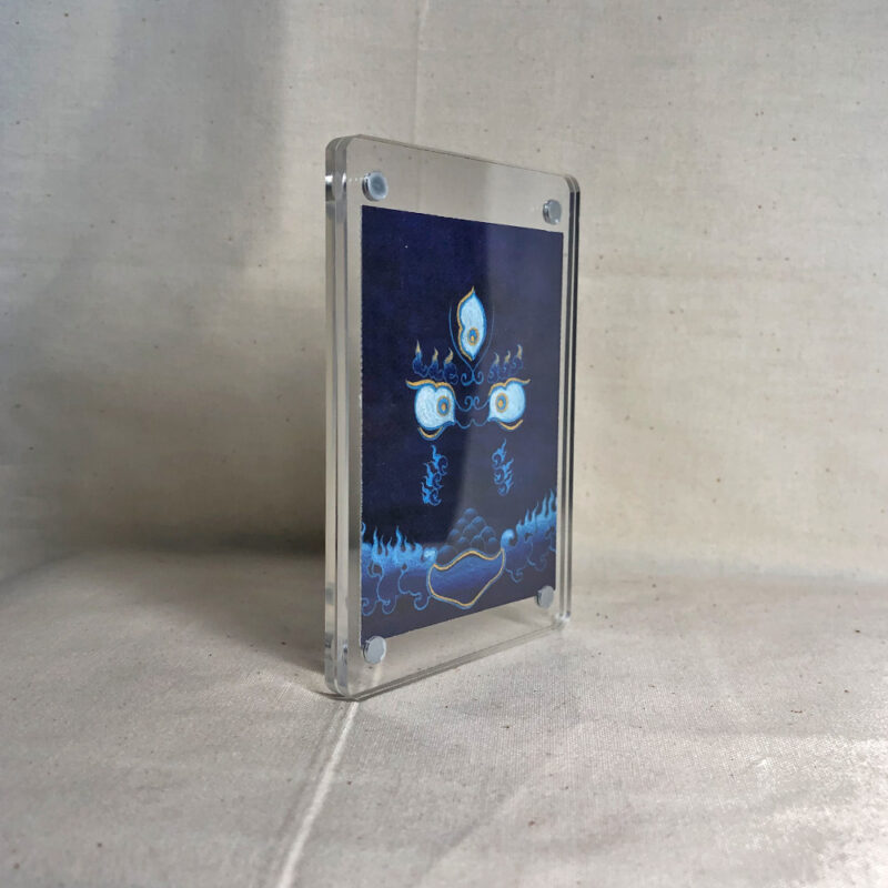 Side-angle view of freestanding clear acrylic block displaying Blue Black Jambhala line art.
