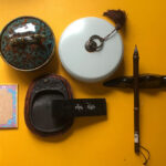 Traditional Chinese calligraphy tools four treasures including brush inkstone and seals on yellow background