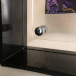 Close-up of magnetic floating screw corner on clear acrylic desktop frame.