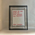 Back view of black acrylic frame displaying Golden Ink Arts custom branding card and signature.