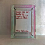 Back view of acrylic frame displaying Golden Ink Arts custom branding card and signature.