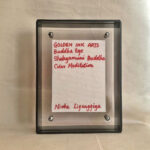 Back view of black acrylic frame displaying Golden Ink Arts custom branding card and signature.
