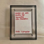 Back view of grey acrylic frame displaying Golden Ink Arts custom branding card and signature.