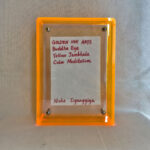 Back view of yellow acrylic frame displaying Golden Ink Arts custom branding card and signature.