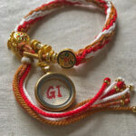 Backside of the Ghau box pendant handwritten with GI studio initials alongside Tibetan charm.