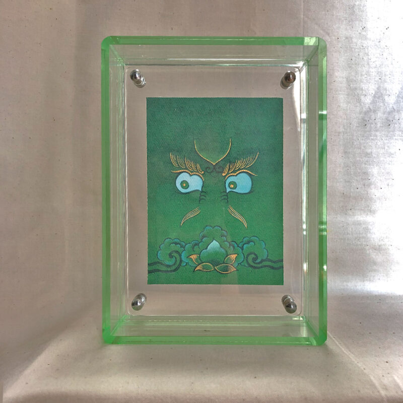 Front view of Green Jambhala Buddha Eyes print in a green floating translucent acrylic frame.