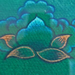 Close-up of original hand-painted gold lotus linework and wisdom eyes on green canvas texture.