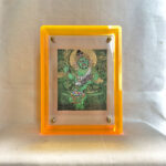 Front view of Green Jambhala Thangka print in a yellow floating translucent acrylic frame.