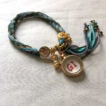 Backside view of the green Green Tara charm bracelet showing the authentic brand emblem.