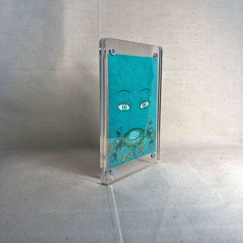 Side-angle view of freestanding clear acrylic block displaying Green Tara line art.