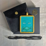 Green Tara Buddha Eyes Gau box necklace presented with cord, pouch, and gift box.
