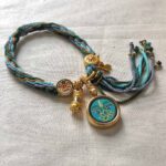 Flatlay layout of the green Green Tara Buddha Eyes braided cord bracelet.