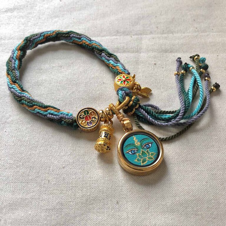 Flatlay layout of the green Green Tara Buddha Eyes braided cord bracelet.