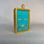 Three-quarter side angle of Green Tara Buddha Eyes gold brass Gau box pendant.