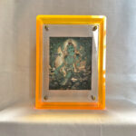 Front view of Green Tara Thangka print in a yellow floating translucent acrylic frame.