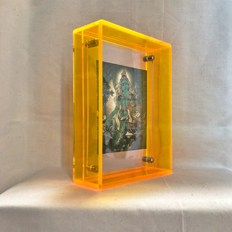 Side perspective of Green Tara Thangka print inside a yellow translucent acrylic display frame.