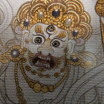 Close-up of HD giclée White Jambhala Thangka print showing wrathful facial features and fine gold linework.