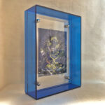 Side perspective of Indigo Black Jambhala Thangka print inside a blue translucent acrylic display frame.
