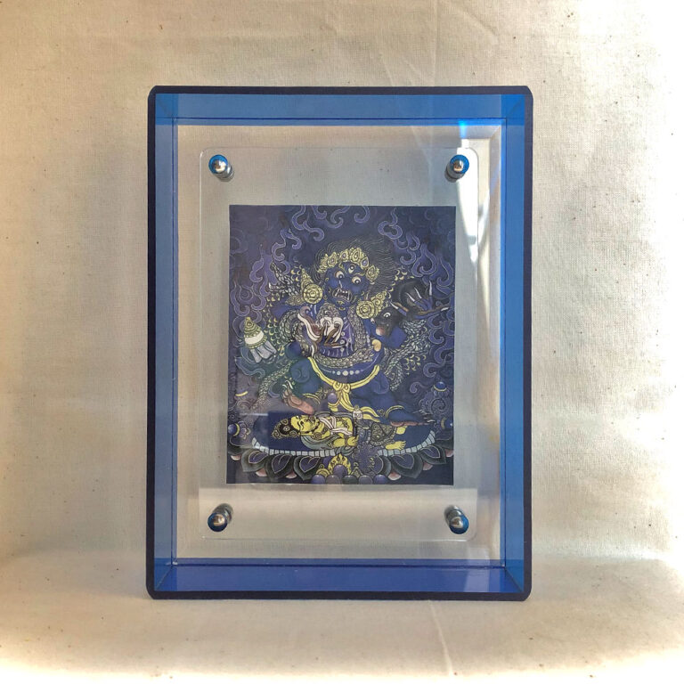 Front view of Indigo Black Jambhala Thangka print in a blue floating translucent acrylic frame.