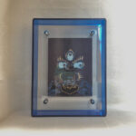 Front view of indigo Mahakala Buddha Eyes print in a blue floating translucent acrylic frame.