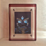 Front view of indigo Yamantaka Buddha Eyes print in a red floating translucent acrylic frame.