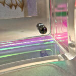 Close-up of magnetic corner screw on rainbow iridescent translucent acrylic display block.