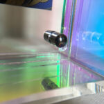 Close-up of magnetic corner screw on iridescent rainbow acrylic display block.