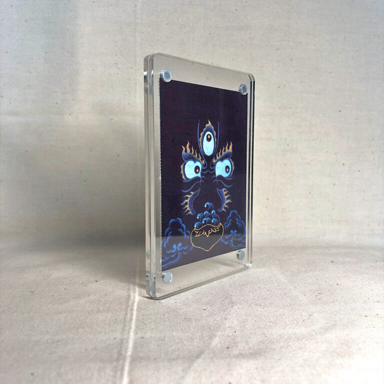 Side-angle view of freestanding clear acrylic block displaying Mahakala line art.