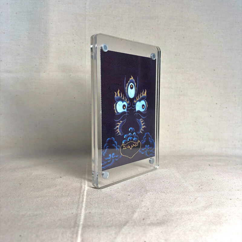 Side-angle view of freestanding clear acrylic block displaying Mahakala line art.
