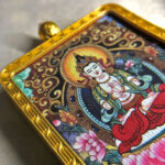 Close-up of Mahasthamaprapta Bodhisattva pendant in gold Gau box for zodiac guardian meditation.