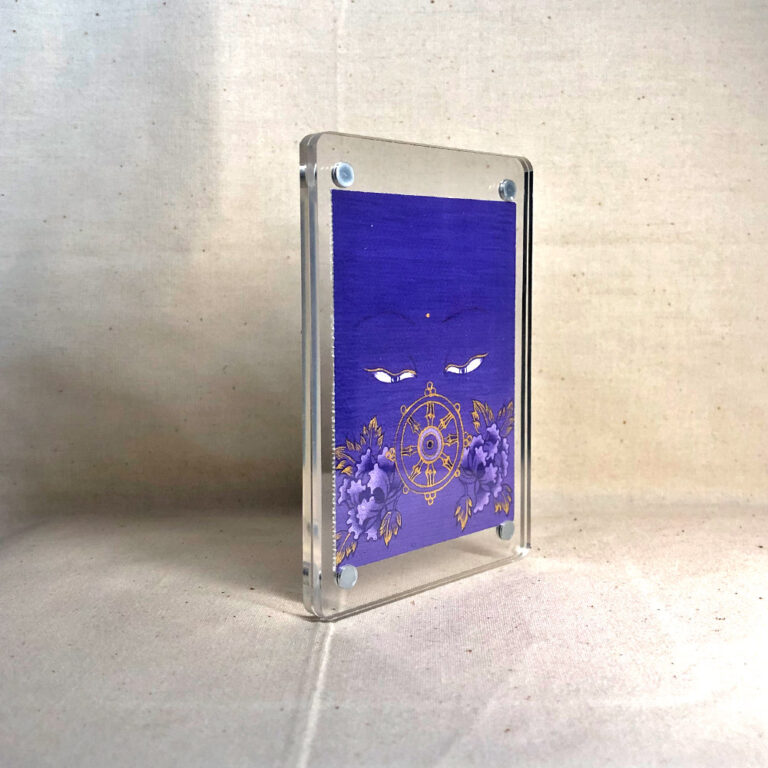 Side-angle view of freestanding clear acrylic block displaying Mahavairocana line art.